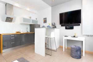 a kitchen with a counter and a tv on the wall at Old Town Neptun Apartments by Renters in Gdańsk