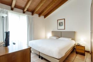 a bedroom with a bed and a desk and a television at Residenza Le Cupole in Parma