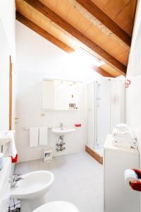 a white bathroom with a sink and a toilet at Residenza Le Cupole in Parma
