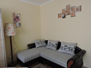 Habitación con sofá con almohadas y lámpara. en Melinda Apartman, en Kaposvár