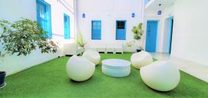 una habitación con sillas blancas y una mesa sobre hierba en Casual de las Letras Sevilla, en Sevilla