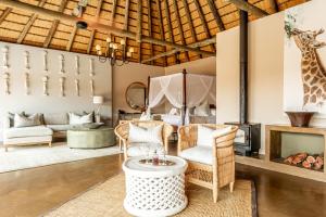 sala de estar con chimenea y jirafa en Lions Valley Lodge en Nambiti Private Game Reserve