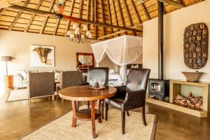 a dining room with a table and chairs and a fireplace at Lions Valley Lodge in Nambiti Private Game Reserve