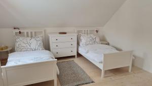 Chalupa Zemulka في Daňkovice: غرفة نوم بسريرين وخزانة بيضاء