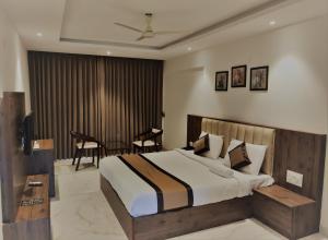 a bedroom with a bed and a table and chairs at Adyar Plaza Inn in Mangalore