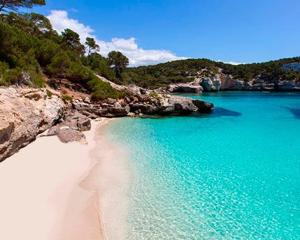 een uitzicht op een strand met blauw water en rotsen bij Menorca Cala Galdana in Cala Galdana
