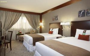 a hotel room with two beds and a television at Holiday Inn Al Khobar - Corniche by IHG in Al Khobar