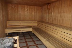 a sauna with wooden walls and benches in a room at Panorama SPA Aparthotel Schillerhof by AlpenTravel in Bad Gastein