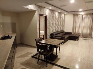 a living room with a table and a couch at Hillcrest Metro in Ooty