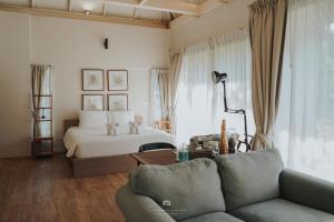 sala de estar con cama y sofá en Sappraiwan Elephant Resort & Sanctuary, en Kaengsopha