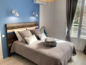 a bedroom with a large bed with a blue wall at Horizon Plage in Hyères