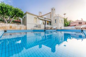 a swimming pool in front of a house at Anna Maria Village in Hersonissos