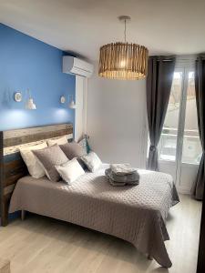 a bedroom with a large bed with a blue wall at Horizon Plage in Hyères