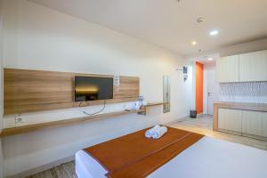 Habitación de hotel con cama y TV en Skyview Sentul Tower Apartments en Bogor