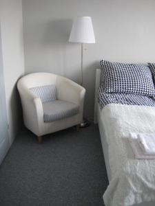 sypialnia z krzesłem, łóżkiem i lampką w obiekcie Apartamenty i pokoje Pluszak w mieście Sandomierz