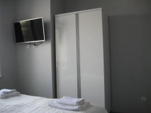 sypialnia z białą szafą z ręcznikami na łóżku w obiekcie Apartamenty i pokoje Pluszak w mieście Sandomierz
