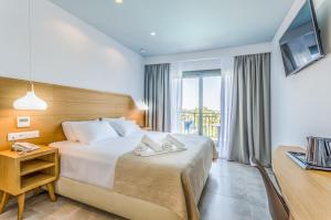 a hotel room with a bed and a television at Anna Maria Village in Hersonissos