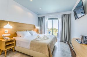 ヘルソニソスにあるAnna Maria Villageのベッドとテレビが備わるホテルルームです。
