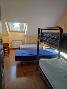 pokój z dwoma łóżkami piętrowymi i oknem w obiekcie La Gallega w mieście Cacabelos