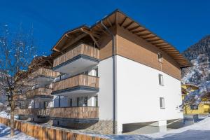 巴特霍夫加施泰因的住宿－Haus Bergblick by AlpenTravel，一座带木制阳台的雪地建筑