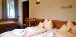 a bedroom with a bed with white sheets and pillows at Hotel Děvín in Pec pod Sněžkou