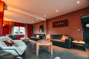 a living room with two couches and a table at Le Bonheur de la Cascade 24 pers - Malmedy, wellness, jardin, confort in Malmedy