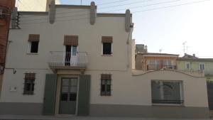 a white building with green shutters and a balcony at Casa Boixader in Navás