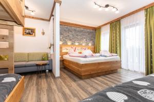 a bedroom with two beds and a couch at Ferienwohnungen Lackenbauer in Bad Hofgastein +58 photos