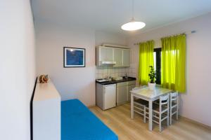 een kleine keuken met een tafel en een geel gordijn bij Anna Maria Village in Chersonissos