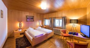 - une chambre avec un lit et un bureau avec un ordinateur dans l'établissement Parc Hotel Florian, à Alpe di Siusi
