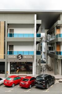 two cars parked in a parking lot in front of a hotel at SVOK Hotel in Tawau