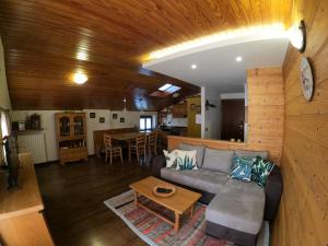 un salon avec un canapé et une table dans l'établissement Mansarda Bellavista - Your Mountain Holiday, à Premana