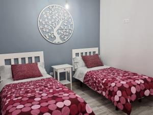 1 dormitorio con 2 camas y espejo en la pared en Sarelen, en Santa Cruz de la Palma