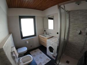 une salle de bain avec un lavabo et une machine à laver dans l'établissement Mansarda Bellavista - Your Mountain Holiday, à Premana