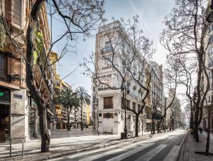 a tall white building on a city street at Mon Suites Benlliure in Valencia