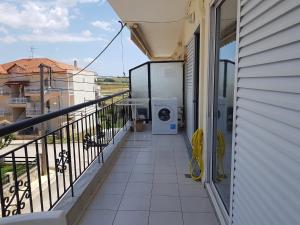 een balkon met een wasmachine aan de zijkant van een huis bij Cozy apartment in Greece in Flogita