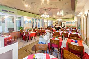 a restaurant with red and white tables and chairs at Hotel Malibran in Venice