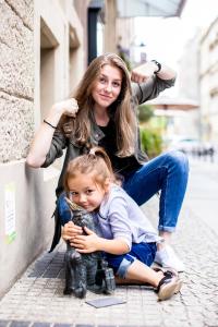 a woman sitting on a curb holding a baby at Art Hotel in Wrocław