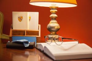 a lamp sitting on top of a table with a book at Hotel Malibran in Venice