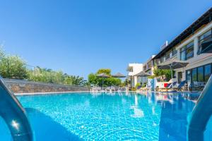 een zwembad met blauw water in een resort bij Anna Maria Village in Chersonissos