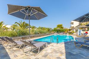 a swimming pool with lounge chairs and an umbrella at Anna Maria Village in Hersonissos