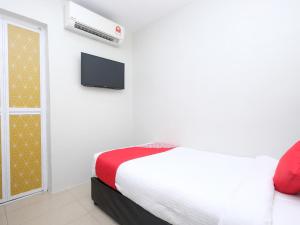 a bedroom with a bed and a tv on a wall at Elite Hotel in Kuantan