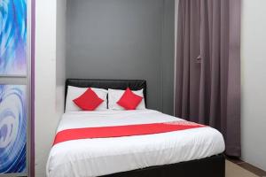 Bett mit roten Kissen in einem Zimmer in der Unterkunft Elite Hotel in Kuantan + 6 Fotos