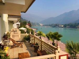 a balcony of a house with a view of the water at Yog Niketan By Sanskriti in Rishīkesh