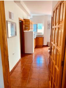 een keuken met een witte koelkast en een tegelvloer bij Apartamento La Real 2 in San Nicolás