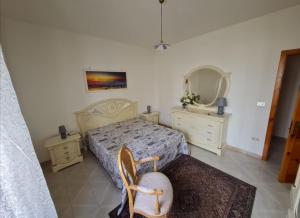 una camera con un letto, due cassettiere e uno specchio di Amata Villa Vacanza a Leuca