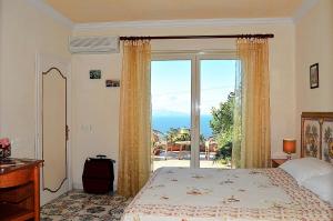 a bedroom with a bed and a large glass window at Le Ginestre di Capri BB & Holiday House in Anacapri