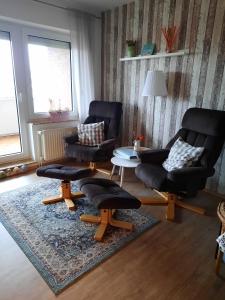 ein Wohnzimmer mit 2 Stühlen und einem Tisch in der Unterkunft Kleine Seenadel in Dornumersiel