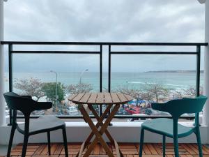 a table and two chairs in front of a large window at 南灣陽光皮小妞 Pii hostel in Nanwan