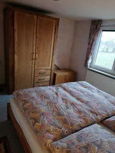 a bedroom with a bed with a dresser and a window at Ferienwohnung Wiesenweg in Bad Bederkesa